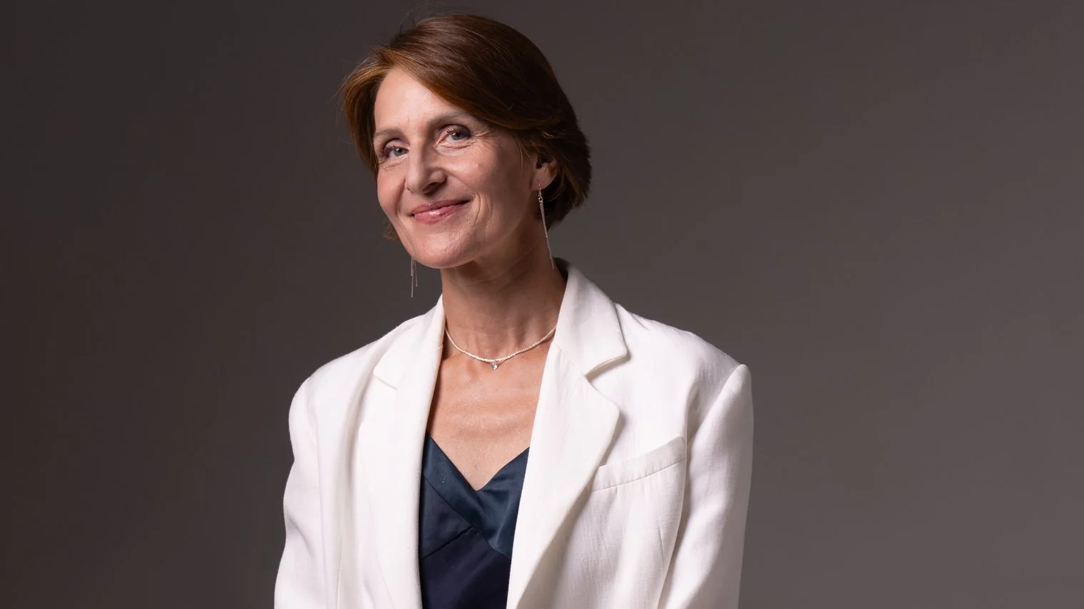 Portrait de Laurence Arpi en veste blanche, sourire calme