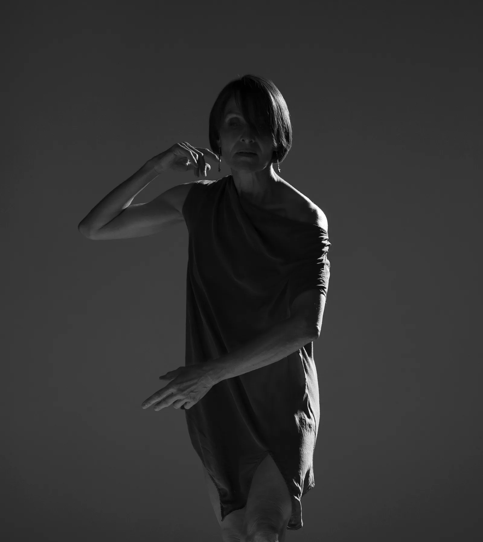 Laurence Arpi en marche consciente, tunique de travail, photographie de studio en noir et blanc
